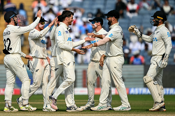 New Zealand's Mitchell Santner (C) celebrates with teammates after taking the wicket of India's Ravichandran Ashwin during the third day of the second Test cricket match between India and New Zealand at the Maharashtra Cricket Association Stadium in Pune on October 26, 2024. (Photo by Punit PARANJPE / AFP) / -- IMAGE RESTRICTED TO EDITORIAL USE - STRICTLY NO COMMERCIAL USE -- (Photo by PUNIT PARANJPE/AFP via Getty Images)